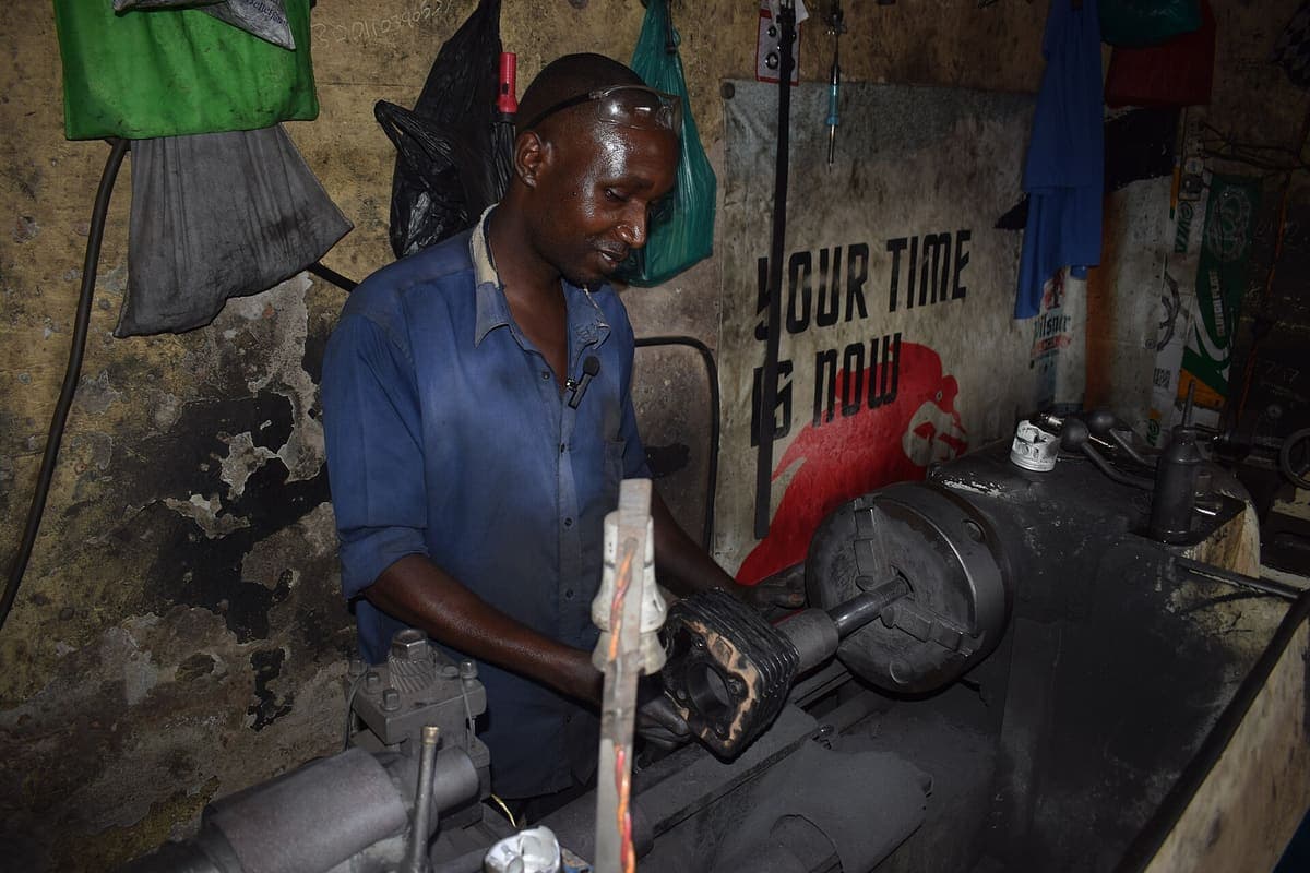 A cylinder boring machine set up over an engine block, its cutting head aligned with one of the cylinder bores