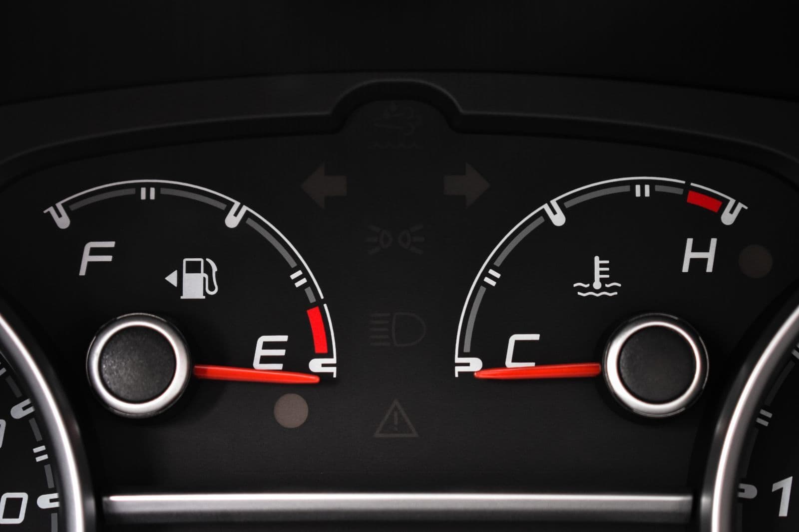 A close-up of a car's instrument panel showing the fuel gauge needle resting on empty beside the temperature gauge.