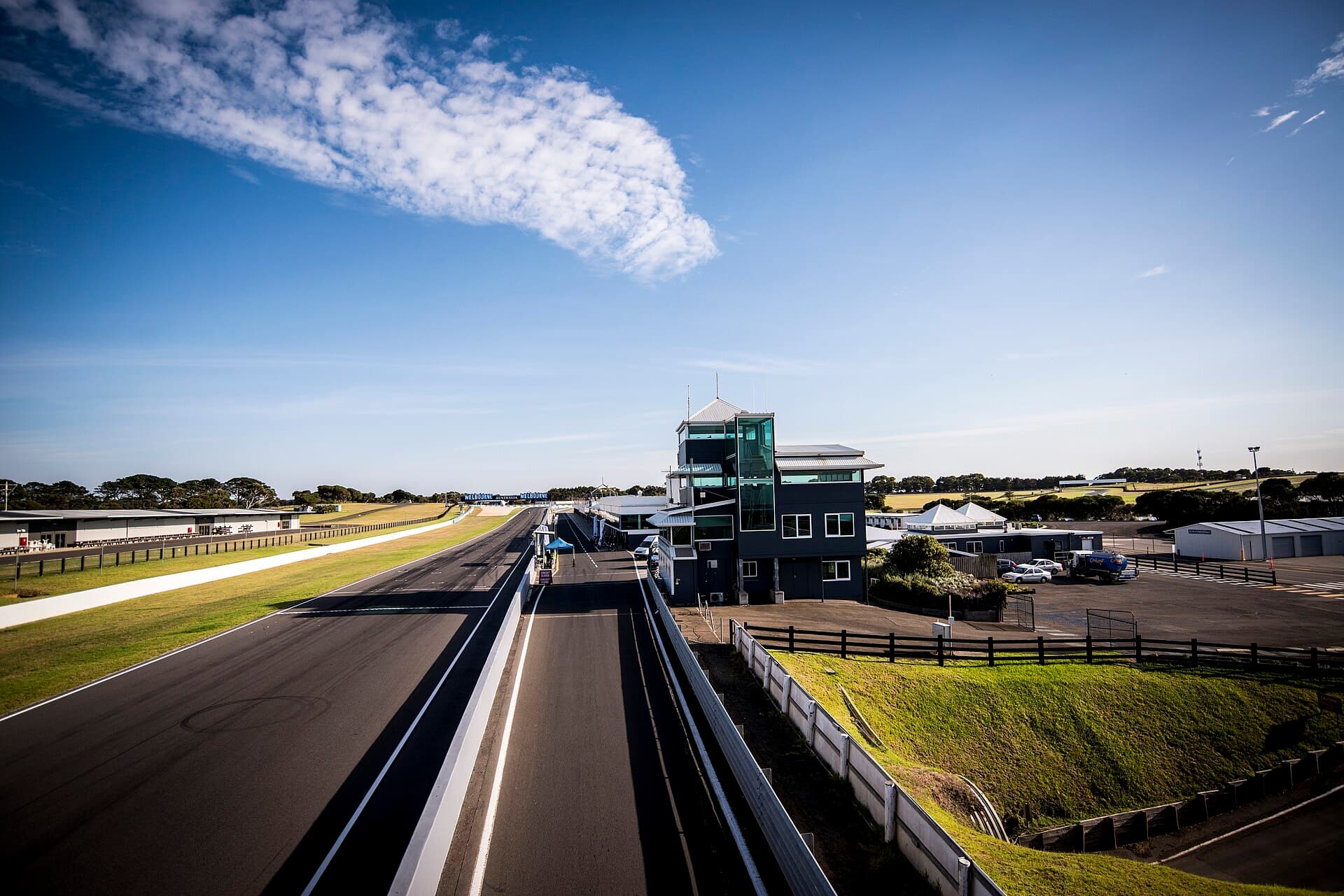The main straight of the Phillip Island Grand Prix Circuit, with pit buildings and the sea beyond.