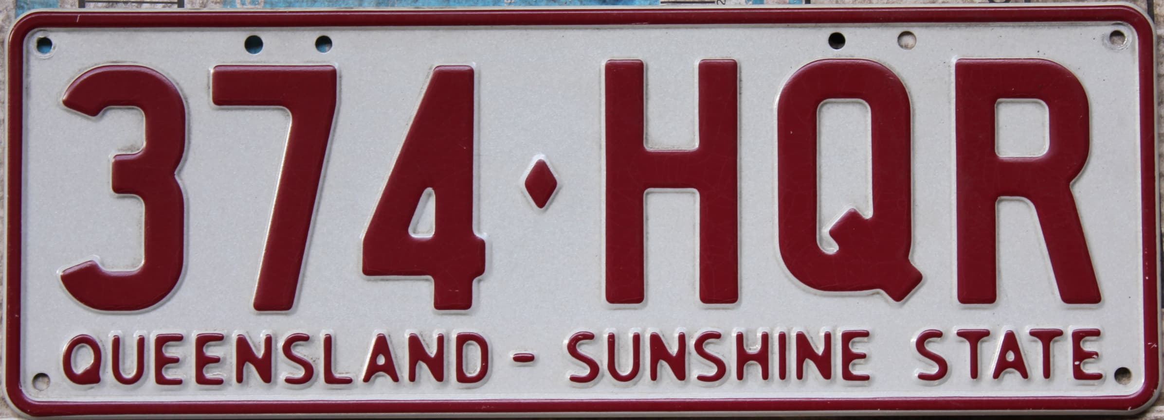Close-up of a de-registered Queensland number plate with a diamond separator and the “Sunshine State” slogan.