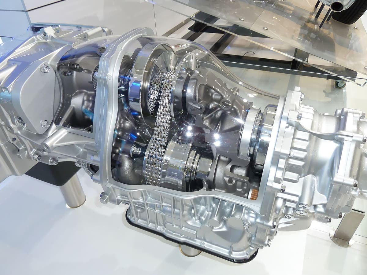 A Subaru Lineartronic continuously variable transmission on display with its casing cut away, showing the two pairs of conical pulleys and the steel drive chain running between them