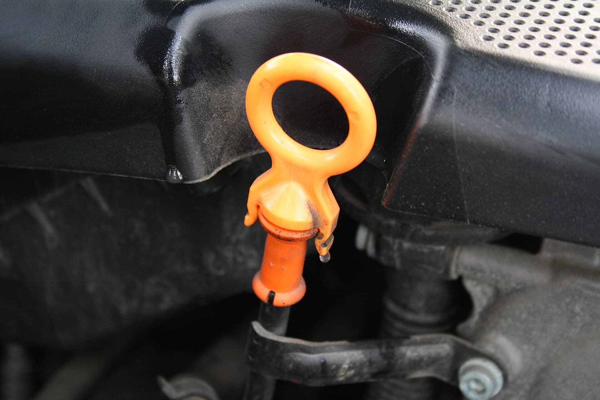 An orange engine oil dipstick handle in the engine bay of a Skoda Fabia