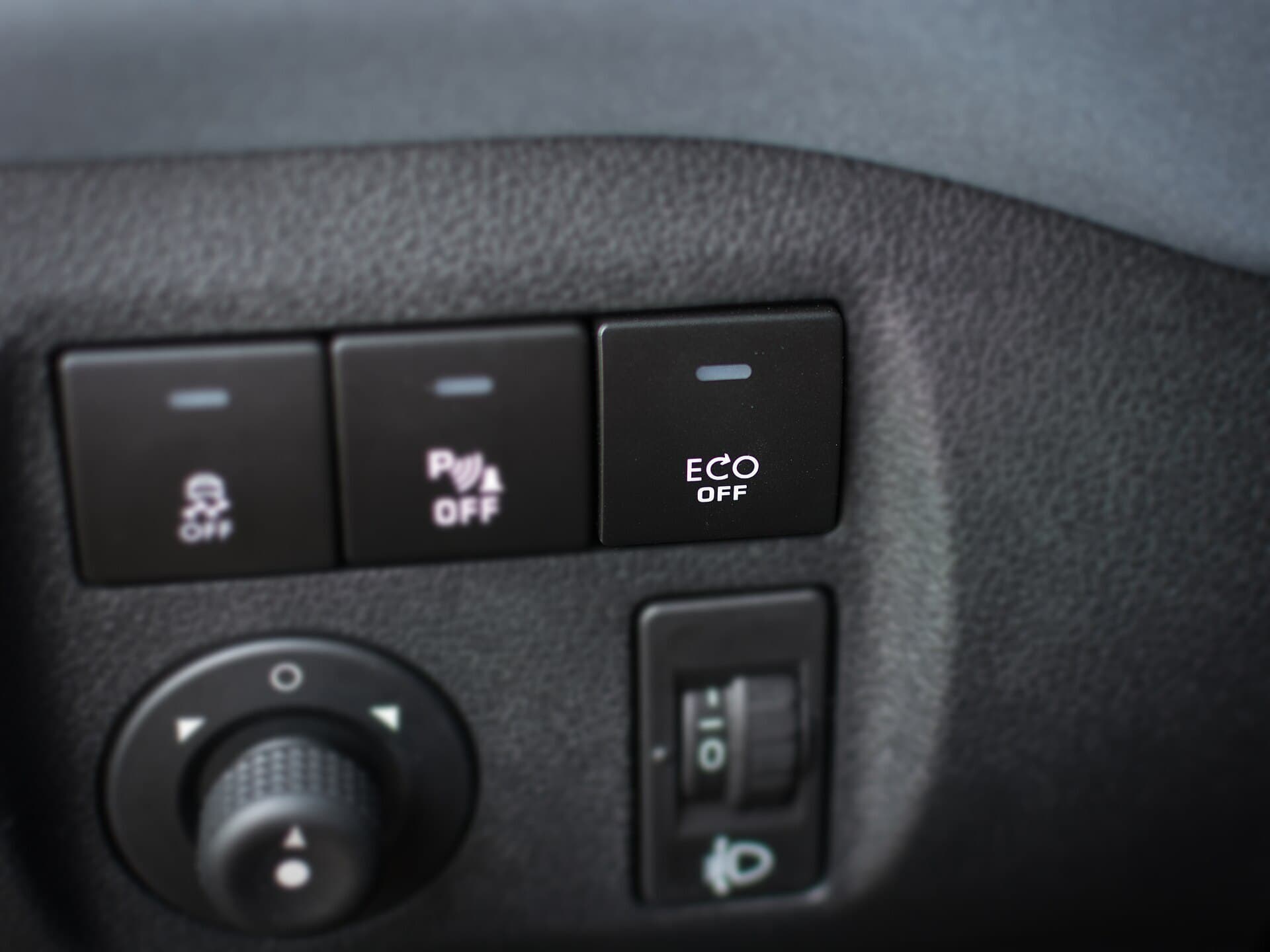 A row of dashboard switches in a Citroen Berlingo, including one labelled ECO OFF that disables the engine stop-start system